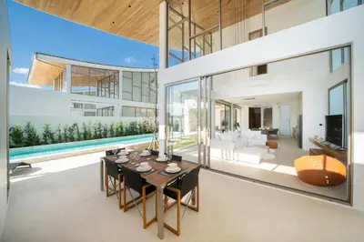 an open living room with a dining table and a pool at Trendy & Minimalist Design 5BR Pool Villa Trinity C1 in Bang Tao Beach