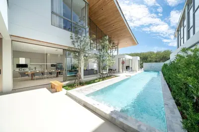 an infinity pool in the backyard of a house at Brand-New & Luxury 5BR Pool Villa Trinity C2 in Bang Tao Beach