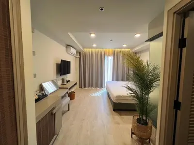 a hotel room with a bed and a potted plant at Karon Boutique in Karon Beach
