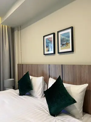 a bedroom with a bed with two pictures on the wall at Karon Boutique in Karon Beach