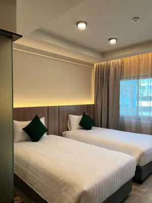 two beds in a room with a window at Karon Boutique in Karon Beach