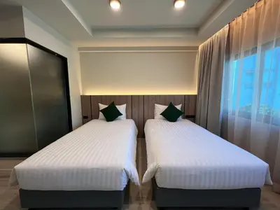 two beds sitting next to each other in a room at Karon Boutique in Karon Beach