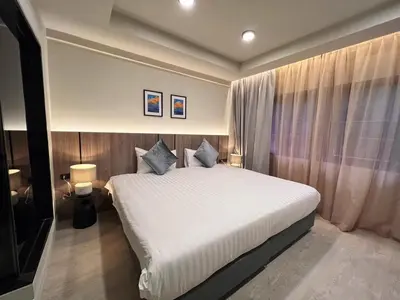 a bedroom with a large white bed and curtains at Karon Boutique in Karon Beach