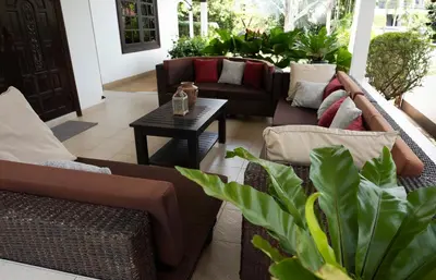 a living room with couches and a table and plants at Kesorn Charming Authentic Thai Pool Villa Phuket in Rawai Beach