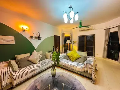 a living room with two couches and a glass table at Kesorn Charming Authentic Thai Pool Villa Phuket in Rawai Beach