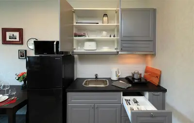 a kitchen with a black refrigerator and a sink at Mountain View Apart Naiyang Beach in Phuket