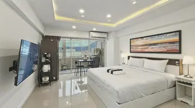 a bedroom with a large white bed and a television at Heritage - Modern Studio shared Pool, City Centre in Patong Beach