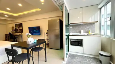 a small kitchen with a table and a refrigerator at Heritage - Modern Studio shared Pool, City Centre in Patong Beach