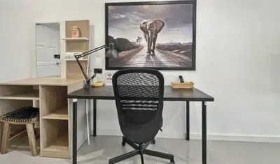 a desk with a chair and a picture of an elephant at Heritage - Modern Studio shared Pool, City Centre in Patong Beach