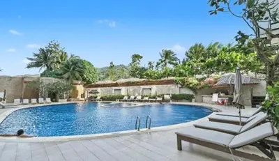 a swimming pool in a yard with lounge chairs at Heritage - Modern Studio shared Pool, City Centre in Patong Beach