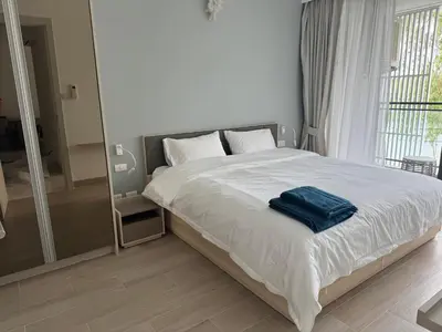 a bedroom with a bed with a blue towel on it at Cassia residences Phuket in Laguna Phuket
