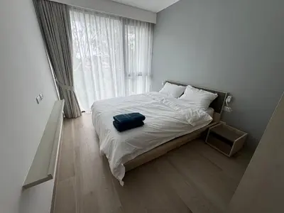a bed in a room with a large window at Cassia residences Phuket in Laguna Phuket