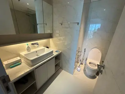 a bathroom with a sink and a toilet and a mirror at Cassia residences Phuket in Laguna Phuket
