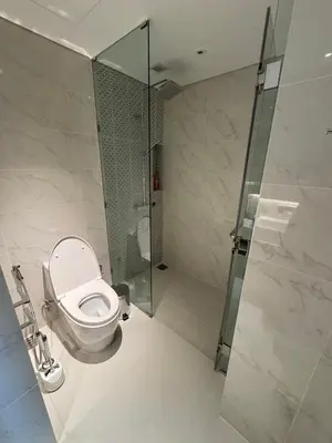 a bathroom with a toilet and a glass shower at Cassia residences Phuket in Laguna Phuket