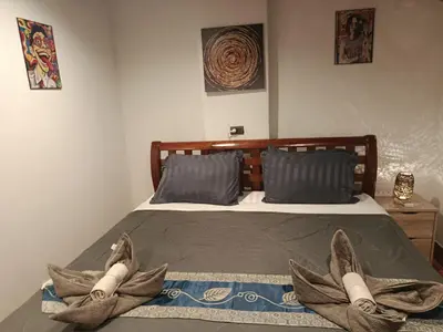 a bedroom with a bed with two pairs of shoes at Hop guest House in Patong Beach