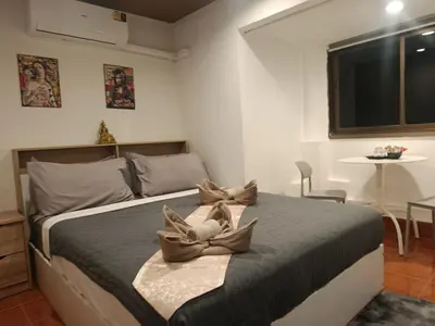 a bedroom with a bed with two pillows on it at Hop guest House in Patong Beach