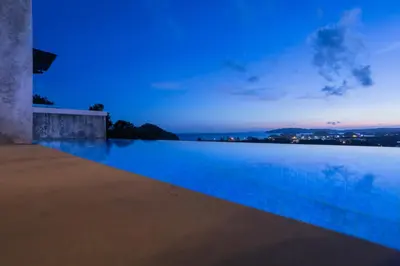 a swimming pool with a blue glow at dusk at Sea & Mountain View Private Pool Villa at Aonang Beach in Krabi town