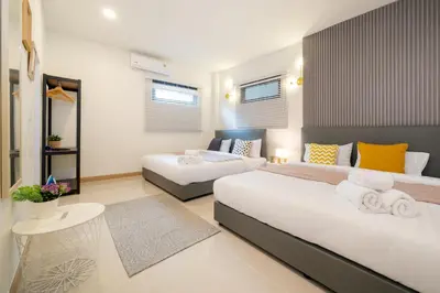a hotel room with two beds and a table at New Charming Patong Pool villa 5 mins walk Bangla beach in Patong Beach