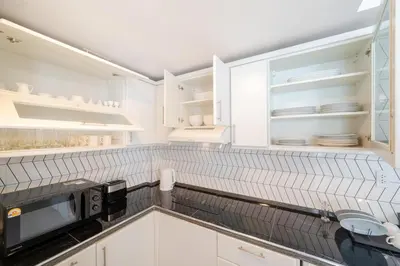 a kitchen with white cabinets and a microwave at New Charming Patong Pool villa 5 mins walk Bangla beach in Patong Beach