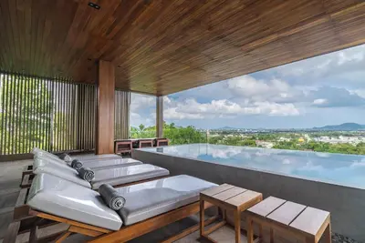 a swimming pool with couches and tables on a building at La Vista by Villacarte in Chalong