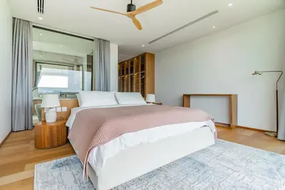 a bedroom with a large bed and a ceiling fan at La Vista by Villacarte in Chalong