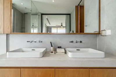 a bathroom with two white sinks and a mirror at La Vista by Villacarte in Chalong