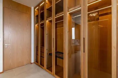 a walk in closet with wooden cabinets and a glass door at La Vista by Villacarte in Chalong