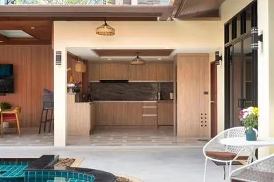 a kitchen and dining area of a house with a pool at Villa Conhei in Rawai Beach