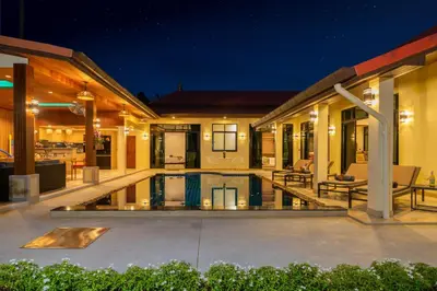 a house with a swimming pool at night at Villa Conhei in Rawai Beach