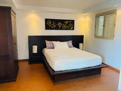 a bedroom with a large bed with a black headboard at Kata Ocean View 1 bedroom Sea View 71 m2 in Kata Beach