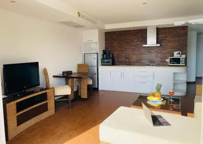 a living room with a couch and a kitchen at Kata Ocean View 1 bedroom Sea View 71 m2 in Kata Beach