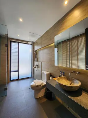 a bathroom with a sink and a toilet and a mirror at Luxury Beachfront BRAHMA Villa 4 Br at Ta-Ke Residence B in Phuket