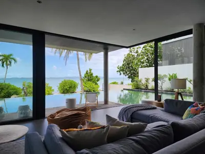 a living room with couches and a view of the ocean at Luxury Beachfront BRAHMA Villa 4 Br at Ta-Ke Residence B in Phuket