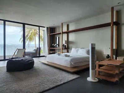a bedroom with a bed and a view of the ocean at Luxury Beachfront BRAHMA Villa 4 Br at Ta-Ke Residence B in Phuket