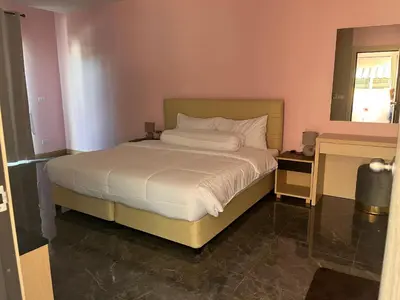 a bedroom with a large bed with white sheets at 2 Bedroom Pool Villa in Ban Na Bon
