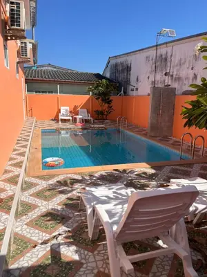 a swimming pool with a chair next to a building at 2 Bedroom Pool Villa in Ban Na Bon