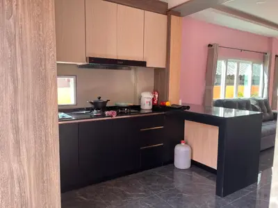 a kitchen with pink walls and a black counter top at 2 Bedroom Pool Villa in Ban Na Bon