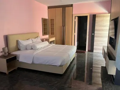 a bedroom with a white bed and a flat screen tv at 2 Bedroom Pool Villa in Ban Na Bon