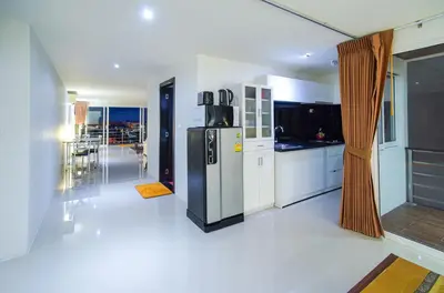 a kitchen with a refrigerator and a dining room at Large, Quiet Corner Condo in Patong Beach