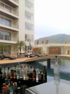a bunch of bottles on a bar in front of a building at Large, Quiet Corner Condo in Patong Beach
