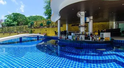 a swimming pool with a bar in the middle of it at Large, Quiet Corner Condo in Patong Beach