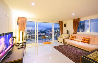 a living room with a couch and a television with a view at Large, Quiet Corner Condo in Patong Beach