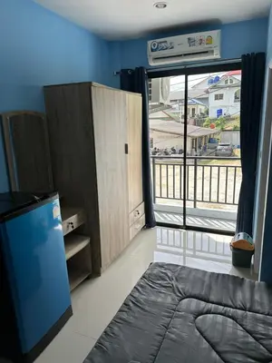 a bedroom with a bed and a large window at Mildmint มายมิ้นท์อพาร์ทเม้นท์ Self Serviced in Kata Beach