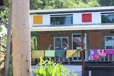 a group of people on the balcony of a house at Hangover Chill & Hill Hostel in Phi Phi Don