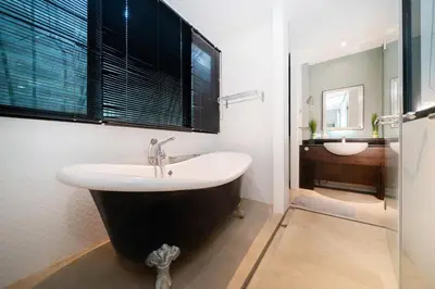 a bathroom with a black and white tub and a sink at Luxurious Villa Near Bangtao Beach in Bang Tao Beach