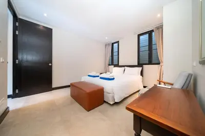 a bedroom with a bed and a desk and a table at Luxurious Villa Near Bangtao Beach in Bang Tao Beach