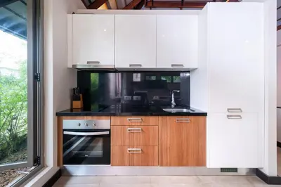 a kitchen with white cabinets and a sink at Luxurious Villa Near Bangtao Beach in Bang Tao Beach