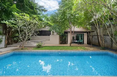 a swimming pool in front of a house at Luxurious Villa Near Bangtao Beach in Bang Tao Beach