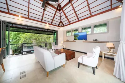 an open living room with white furniture and windows at Luxurious Villa Near Bangtao Beach in Bang Tao Beach