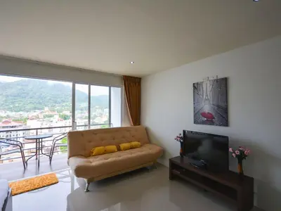 a living room with a couch and a flat screen tv at Large, quiet Condo by รินดา Rinrada in Patong Beach